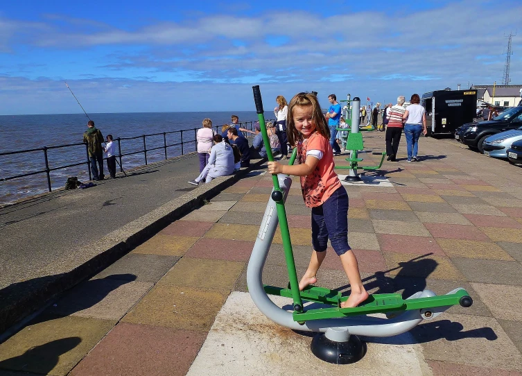 a girl on a scooter near a dock