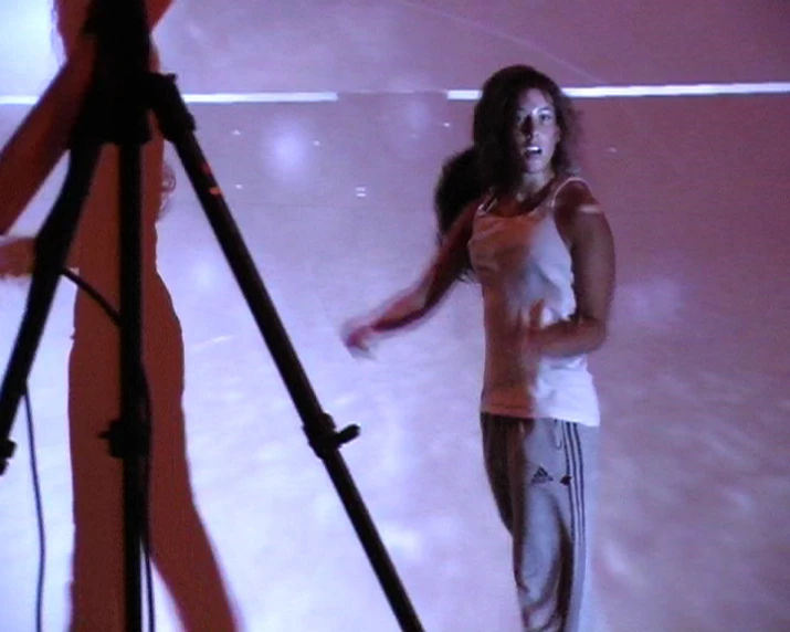 a woman is standing in a room behind a camera