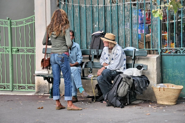 two people on the street sitting at the bench