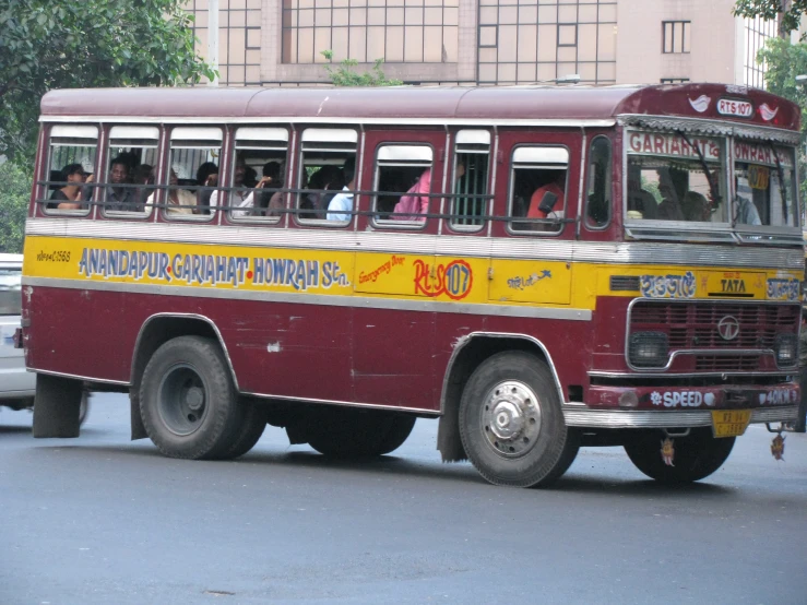 an older bus riding down the road with passengers on it