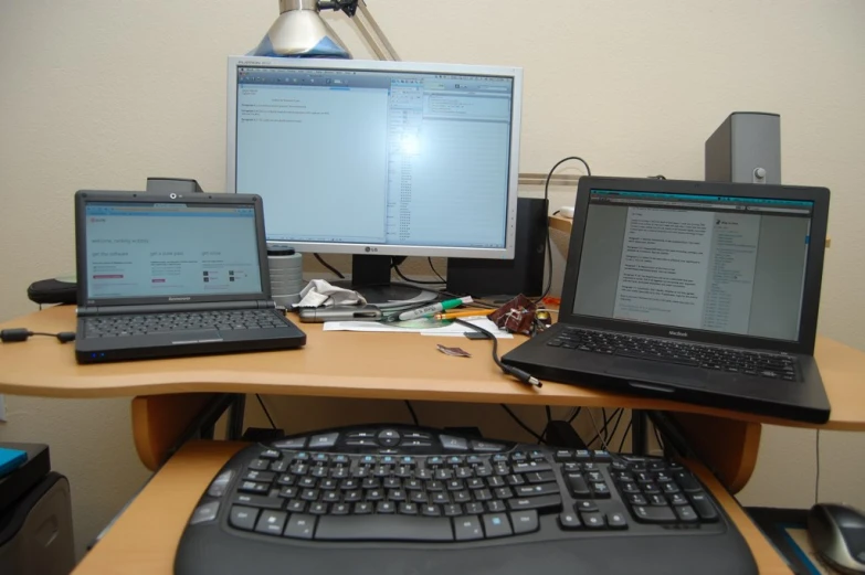 two computers are sitting on a wooden desk