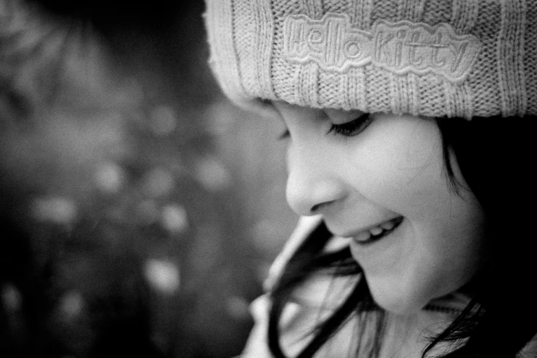 black and white image of woman wearing hat and talking on cell phone