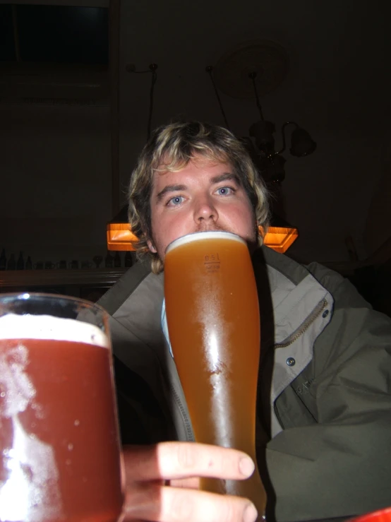 a man is holding a giant mug of beer