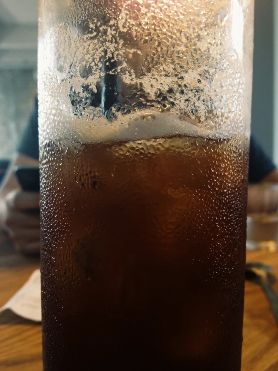 a glass of beer sitting on top of a wooden table