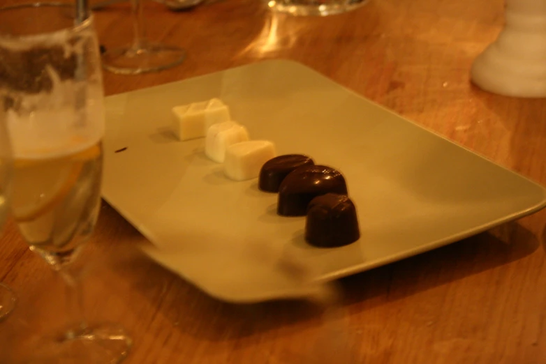 an assortment of chocolates on a plate next to champagne glasses