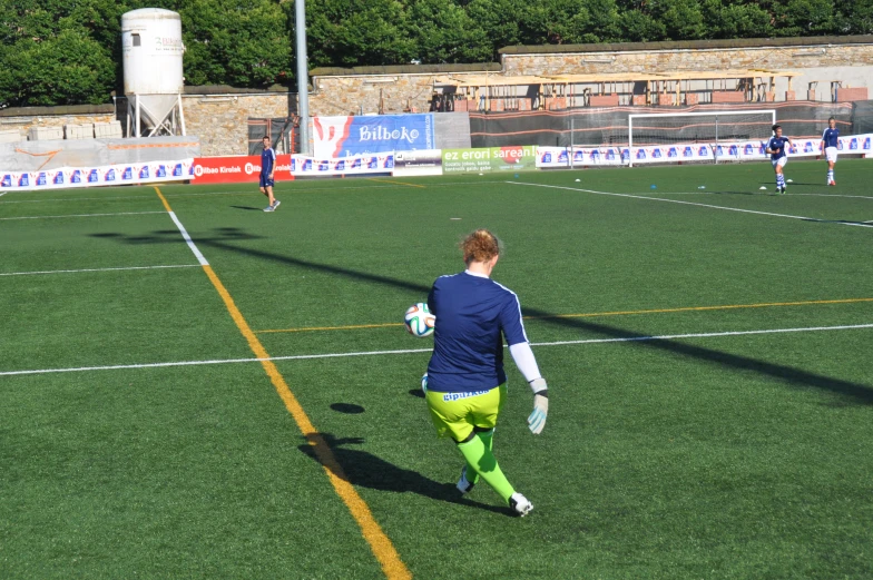 a young man playing soccer in front of other people