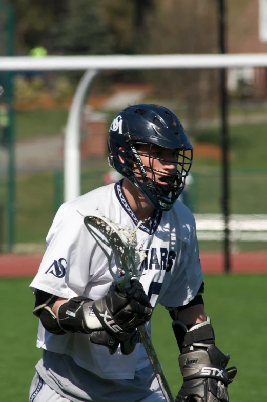 a person holding a lacrosse stick and wearing a uniform