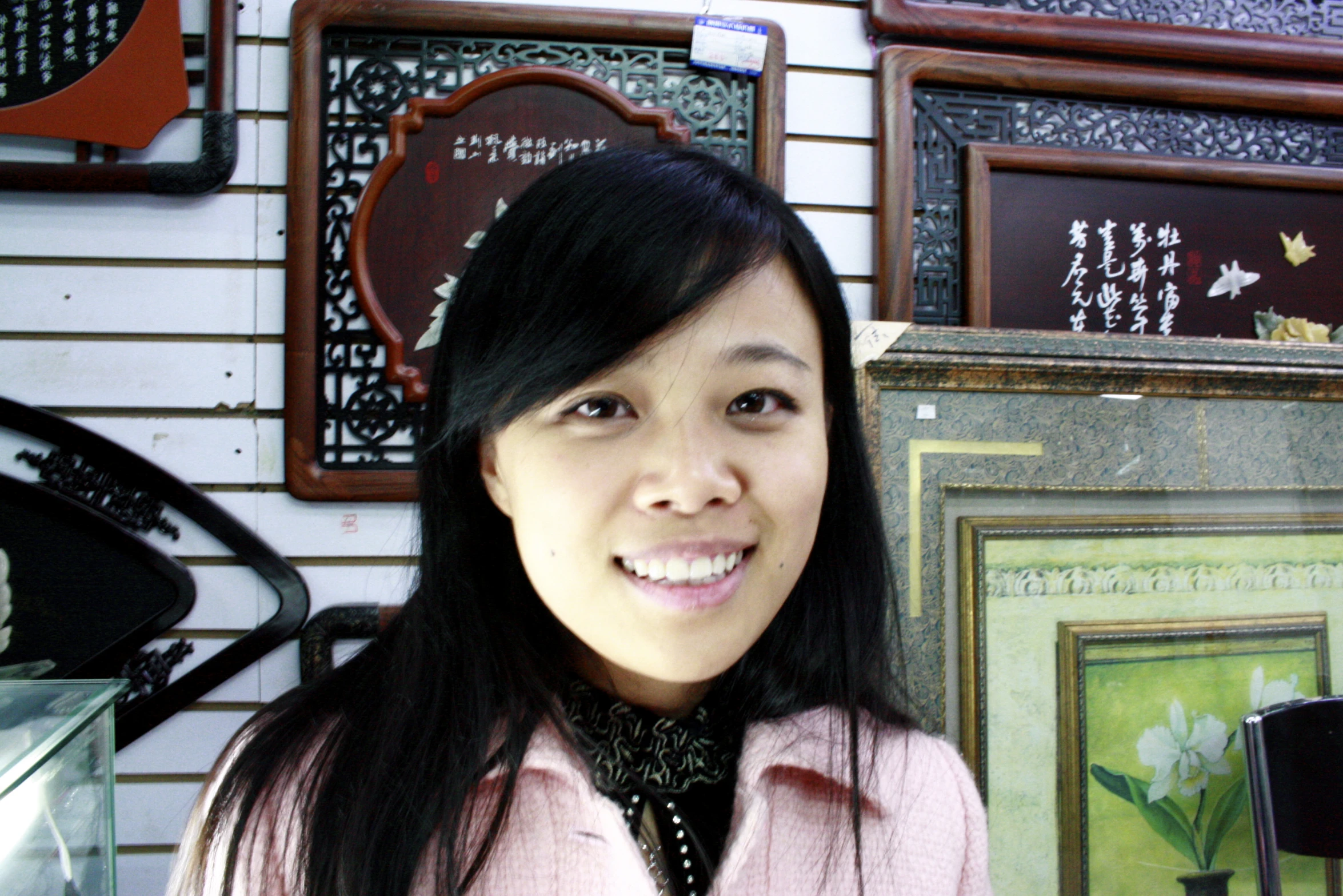 woman in pink coat and accessories in front of frames