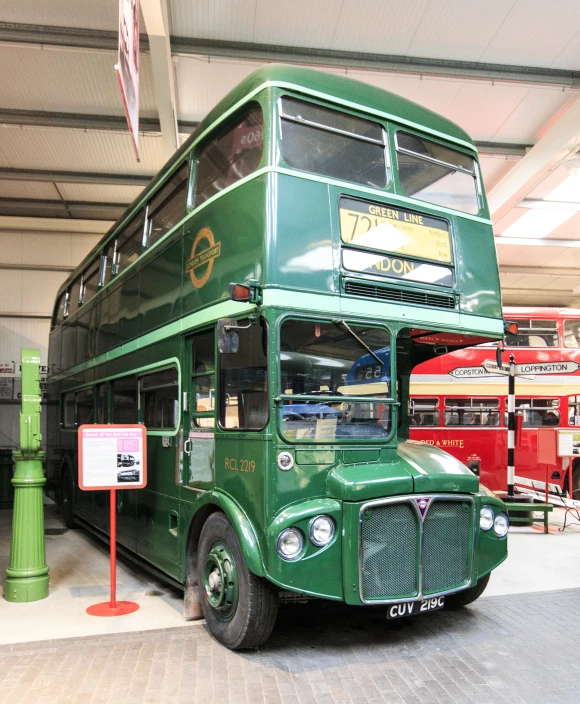 two different colored double decker buses in a building