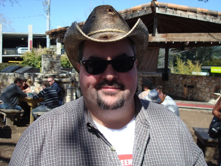 a man wearing sunglasses and a cowboy hat