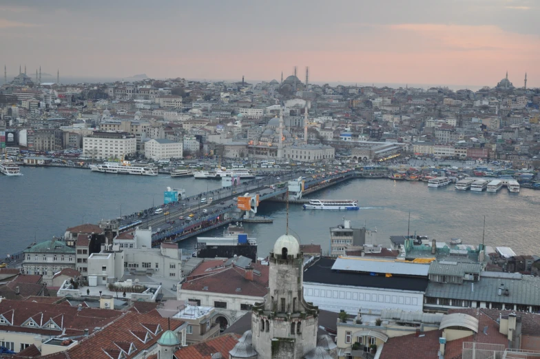 the city view shows tall buildings, a bridge and lots of boats