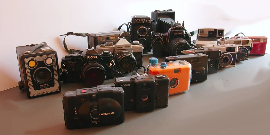 many cameras are sitting on the table with one showing