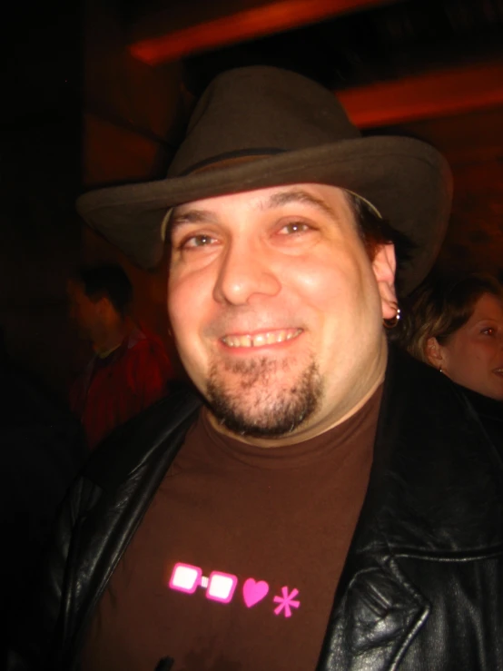 a man wearing a hat is smiling at the camera