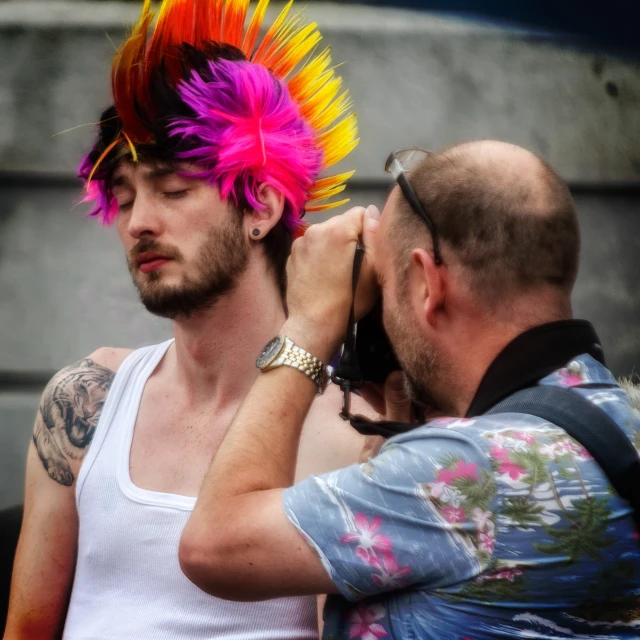 a man with a red and yellow mohawk standing next to another man