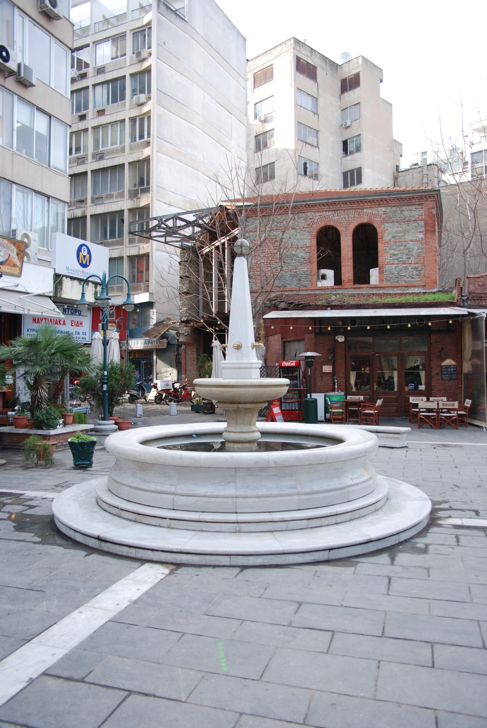 a stone fountain on a city street corner