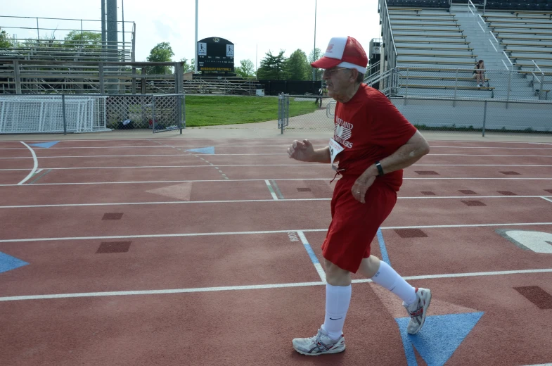 a man wearing an athletic outfit is running across the track