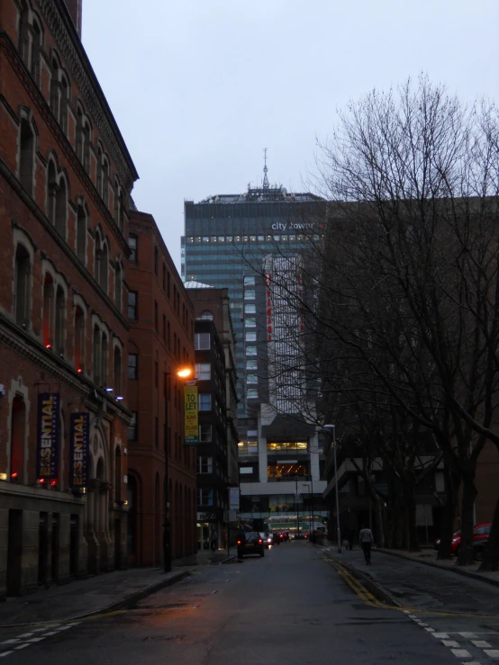 two cars driving down an urban road with a skyscr in the background