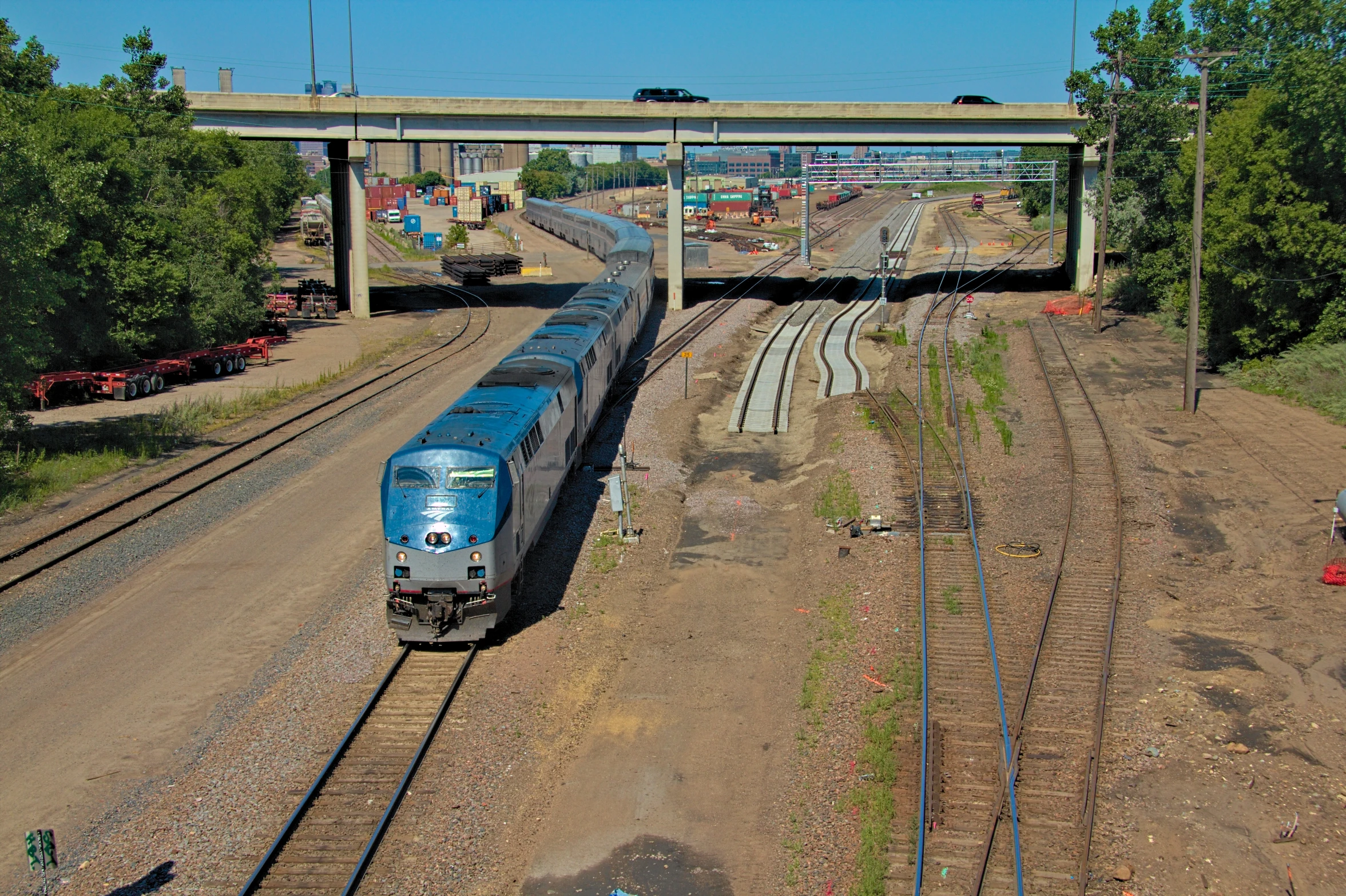 a train traveling down tracks under an overpass