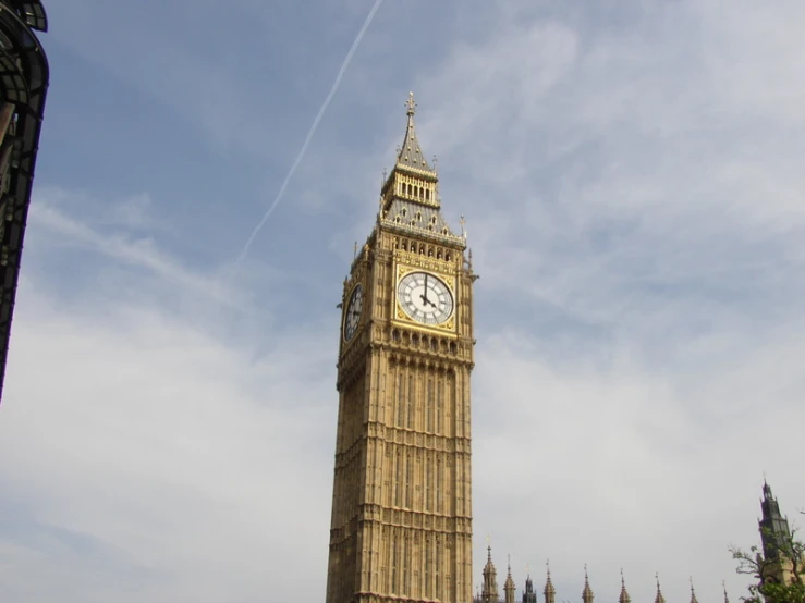 big ben clock tower and blue skies with contrails in the background