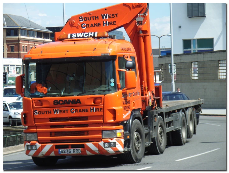 a large orange crane sitting on the back of a truck