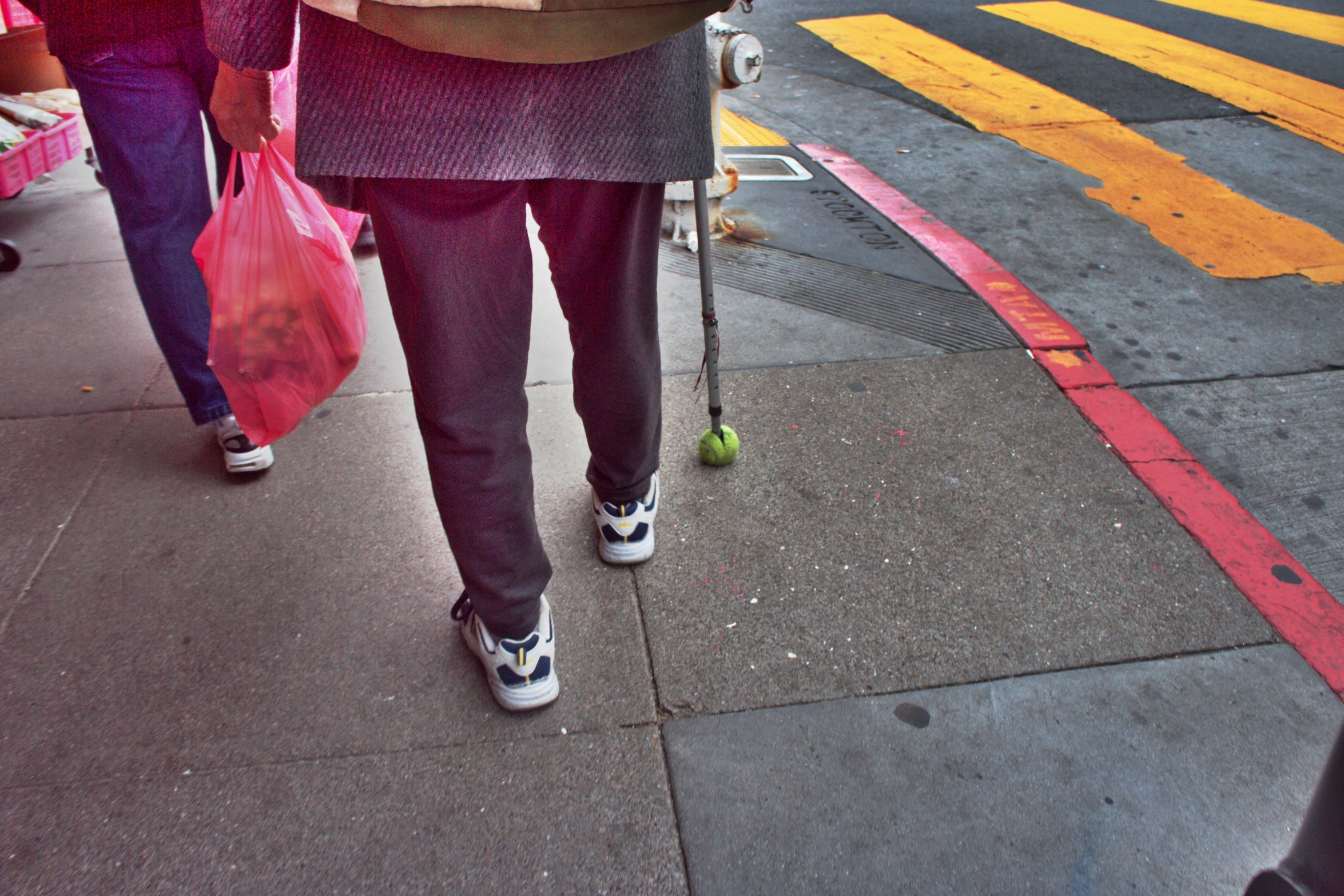 two women walking down the street carrying shopping bags