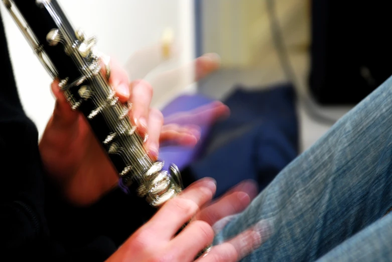 a close up of two hands holding a musical instrument