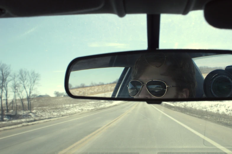 the view of a street and the mirror from a vehicle