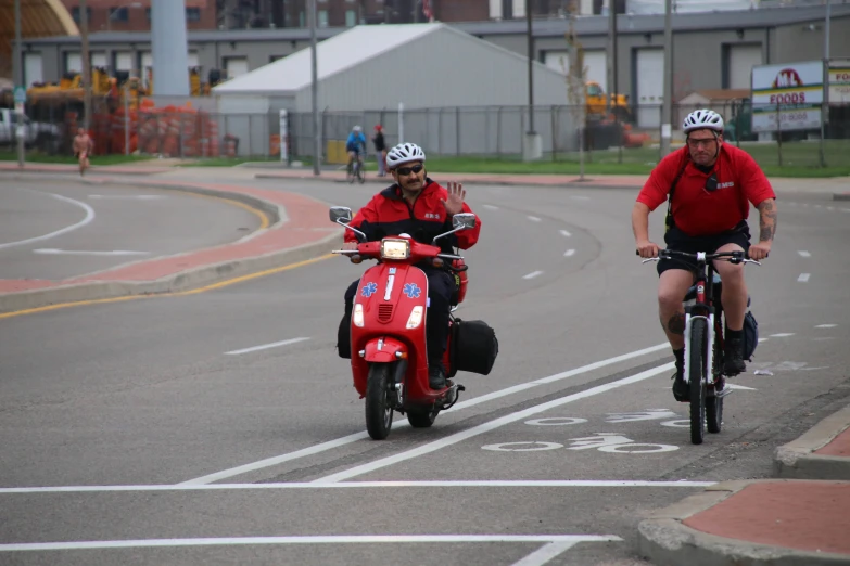 a couple of men riding motorcycles down a street