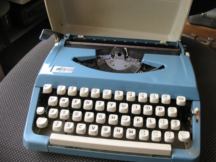 an old fashioned blue typewriter has white keys
