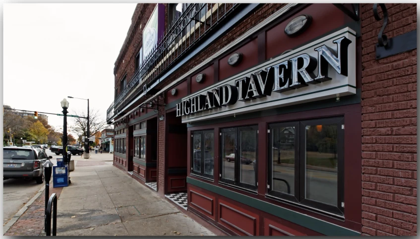 sidewalk area in front of building that has window signs above doorways