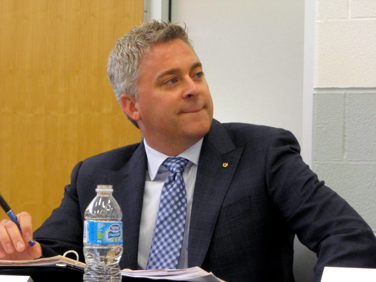 a man sitting at a table with water bottles