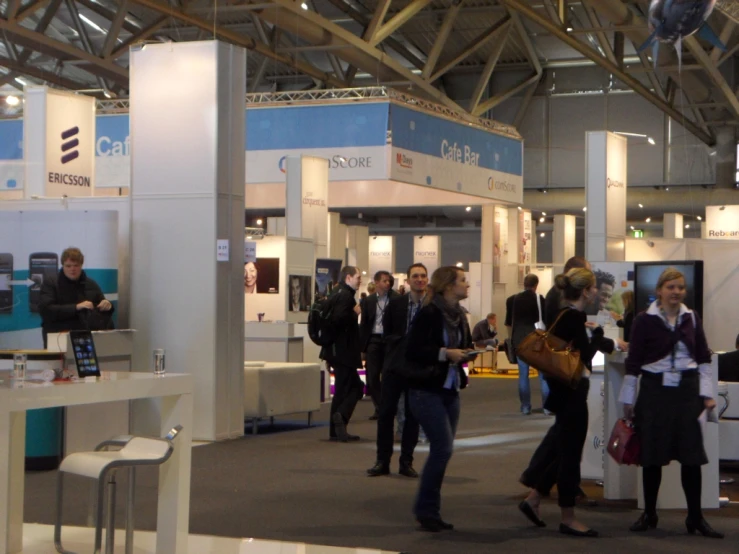 a couple of women talking to each other in a room with tables and booths