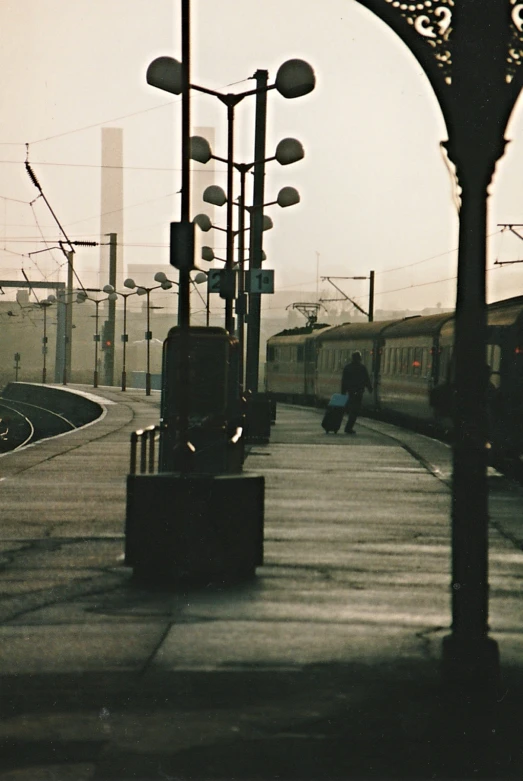 a lone person walks past a train at a station