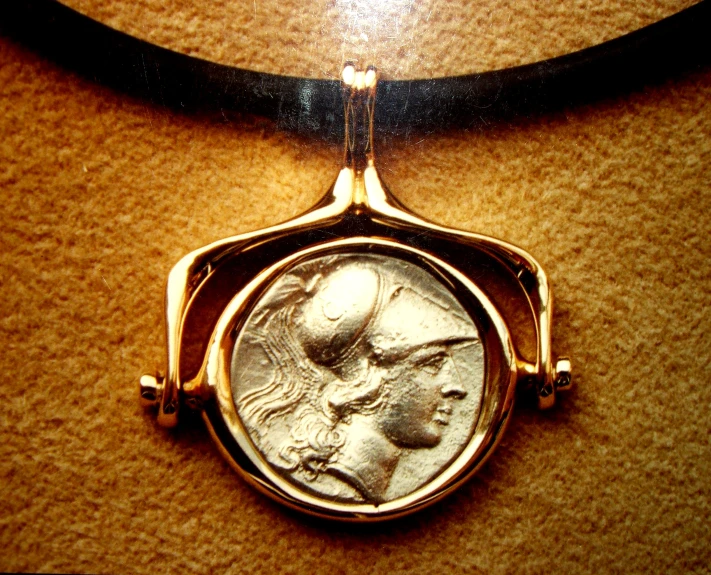 a close up of a coin on a necklace