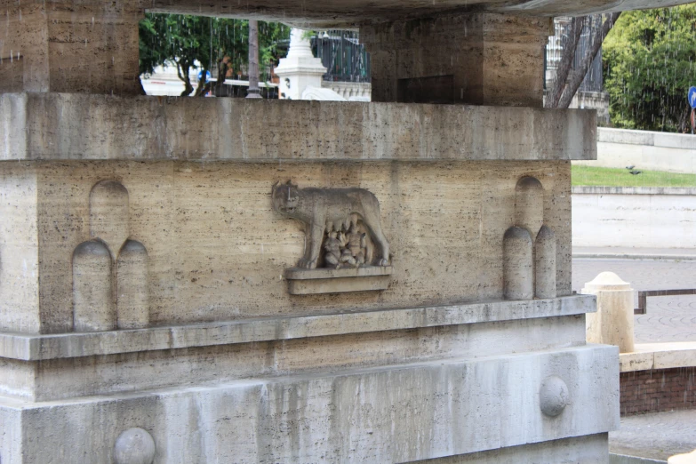 statue with carvings near wall in urban area