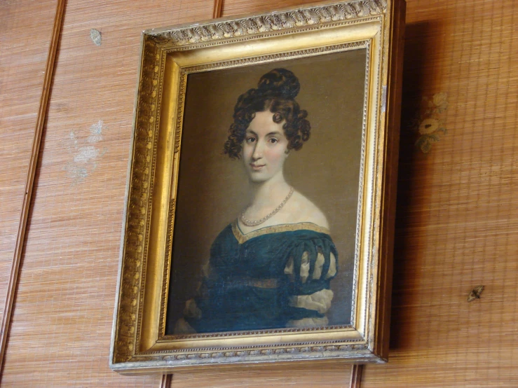 a painting with a woman's blue dress in gold frame