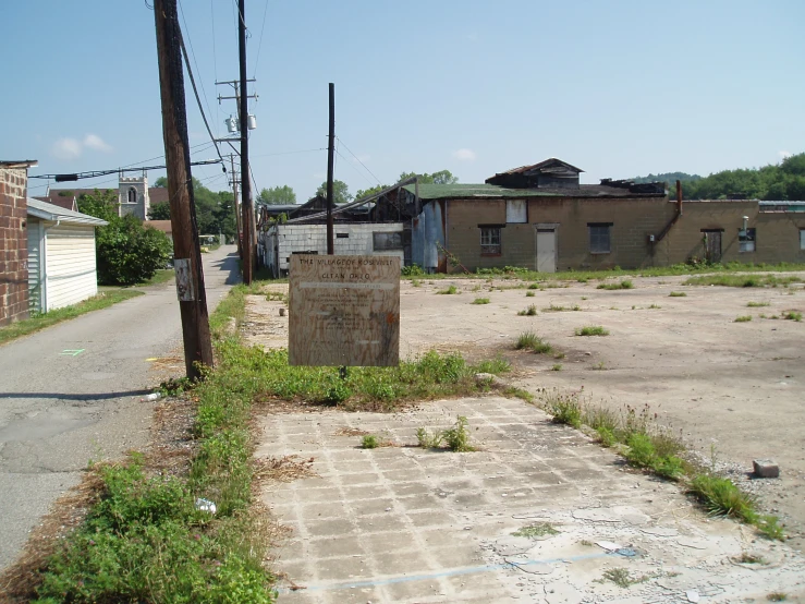 an abandoned house and street with dirt roads