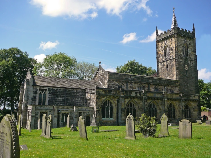 the old gothic building with graveyards has a clock tower