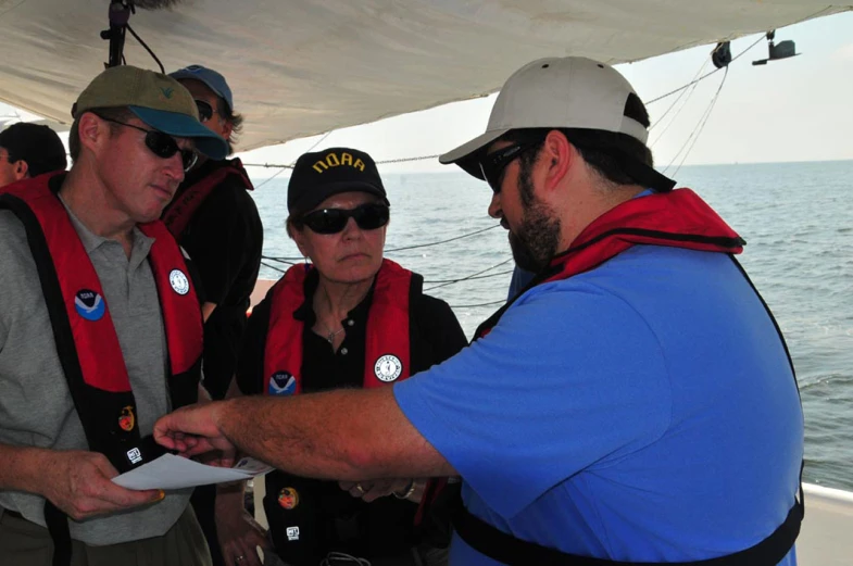 a group of men standing next to each other on a boat