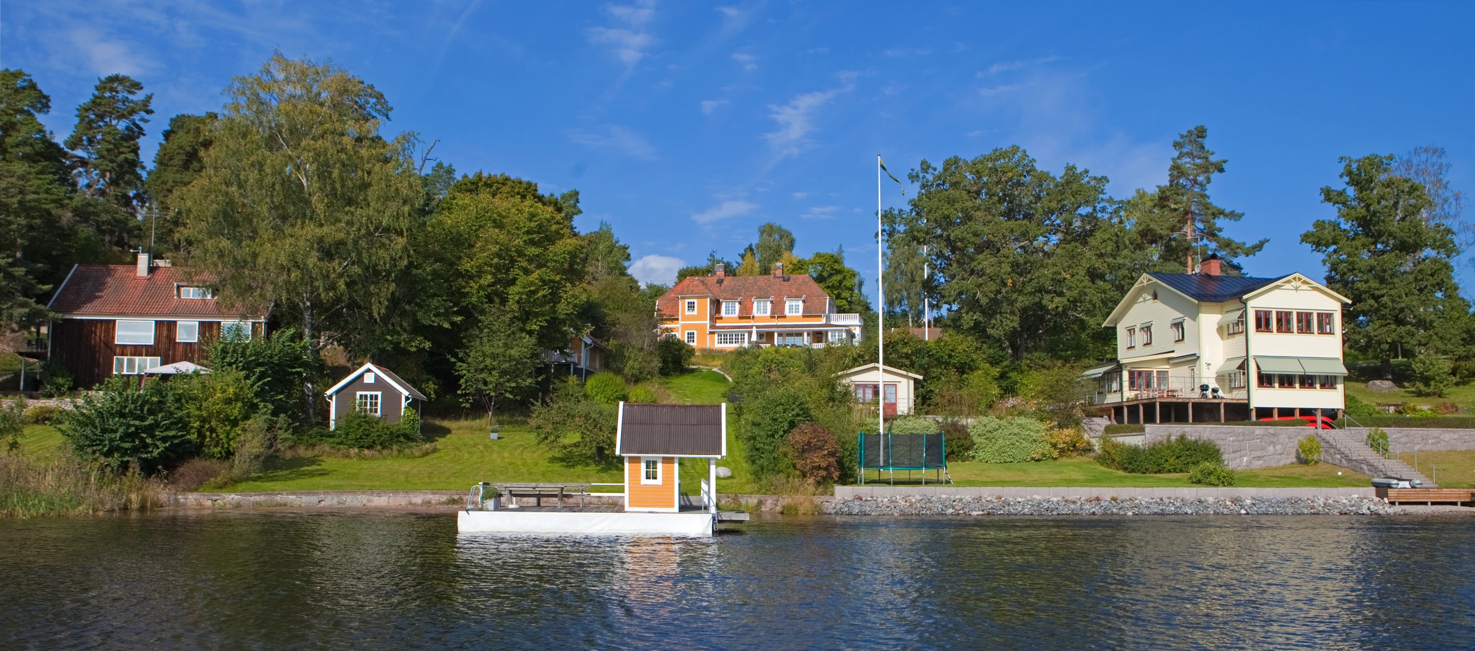 some houses by the water with some trees