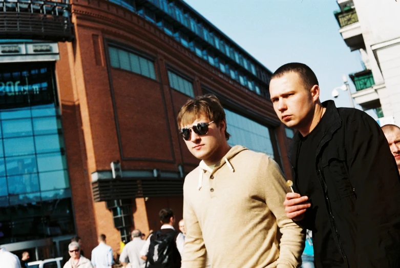 two men walking down a street with some kind of people