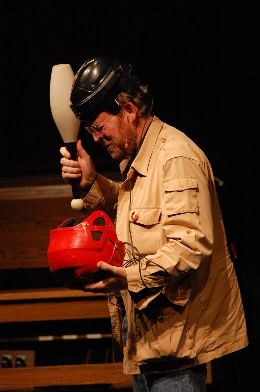 a man wearing a helmet and holding a red object