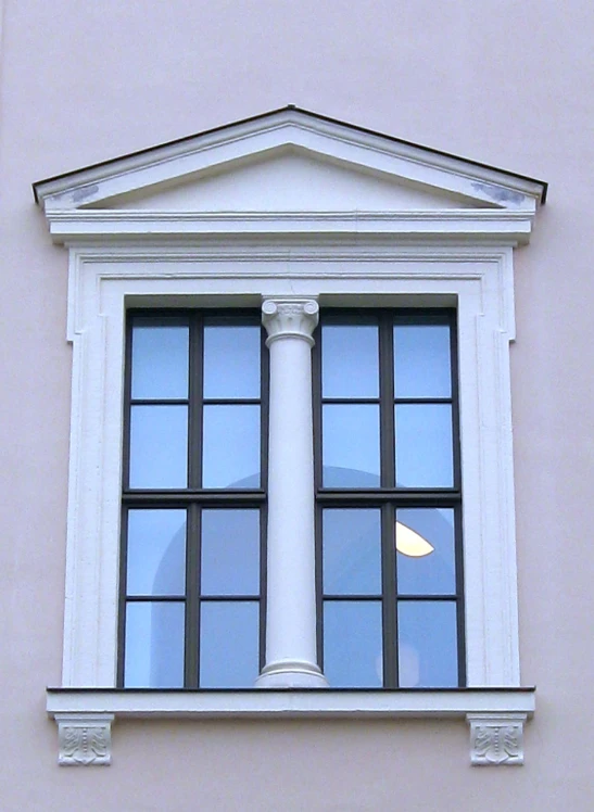 the windows of a building have decorative pillars and an ornamental column