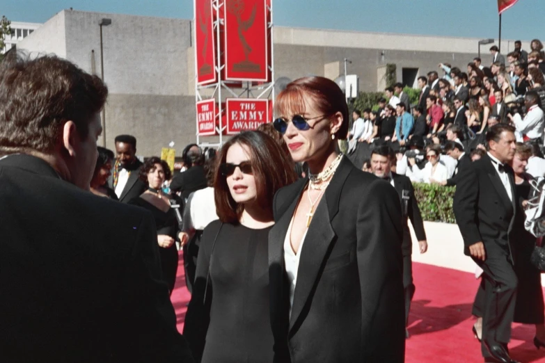 two women walk down the red carpet at an event