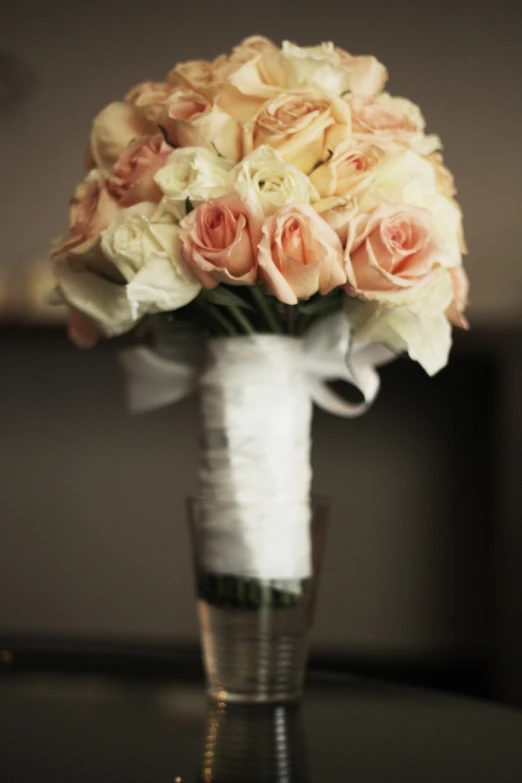 white and blush roses are placed on the edge of a vase