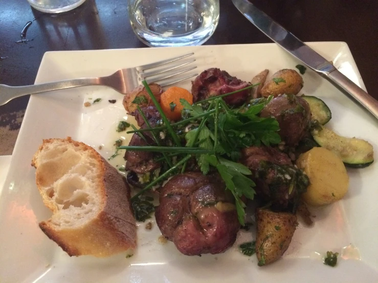 a dish filled with meat and vegetables sitting on a white plate