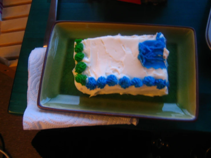 a cake sitting on a green plate and blue and green frosting