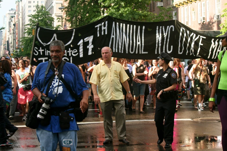 people are walking in the rain in a large parade