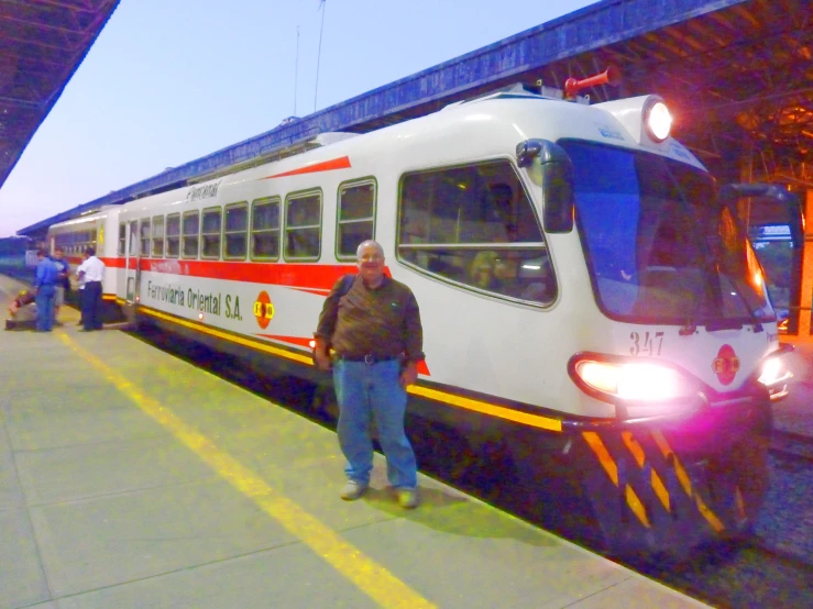 a man stands on the platform waiting to board a train