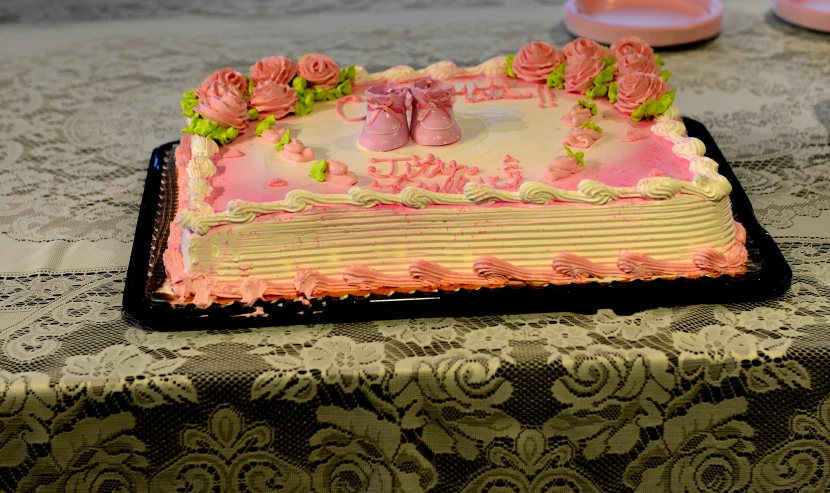 a cake with pink decorations is displayed on the table